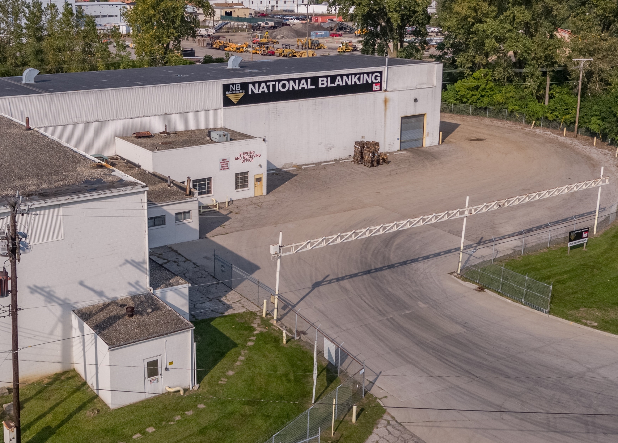 National Blanking Heidtman Joint Venture Facility Aerial View Aerial view of National Blanking facility with large white building, signage, and fenced parking lot.
