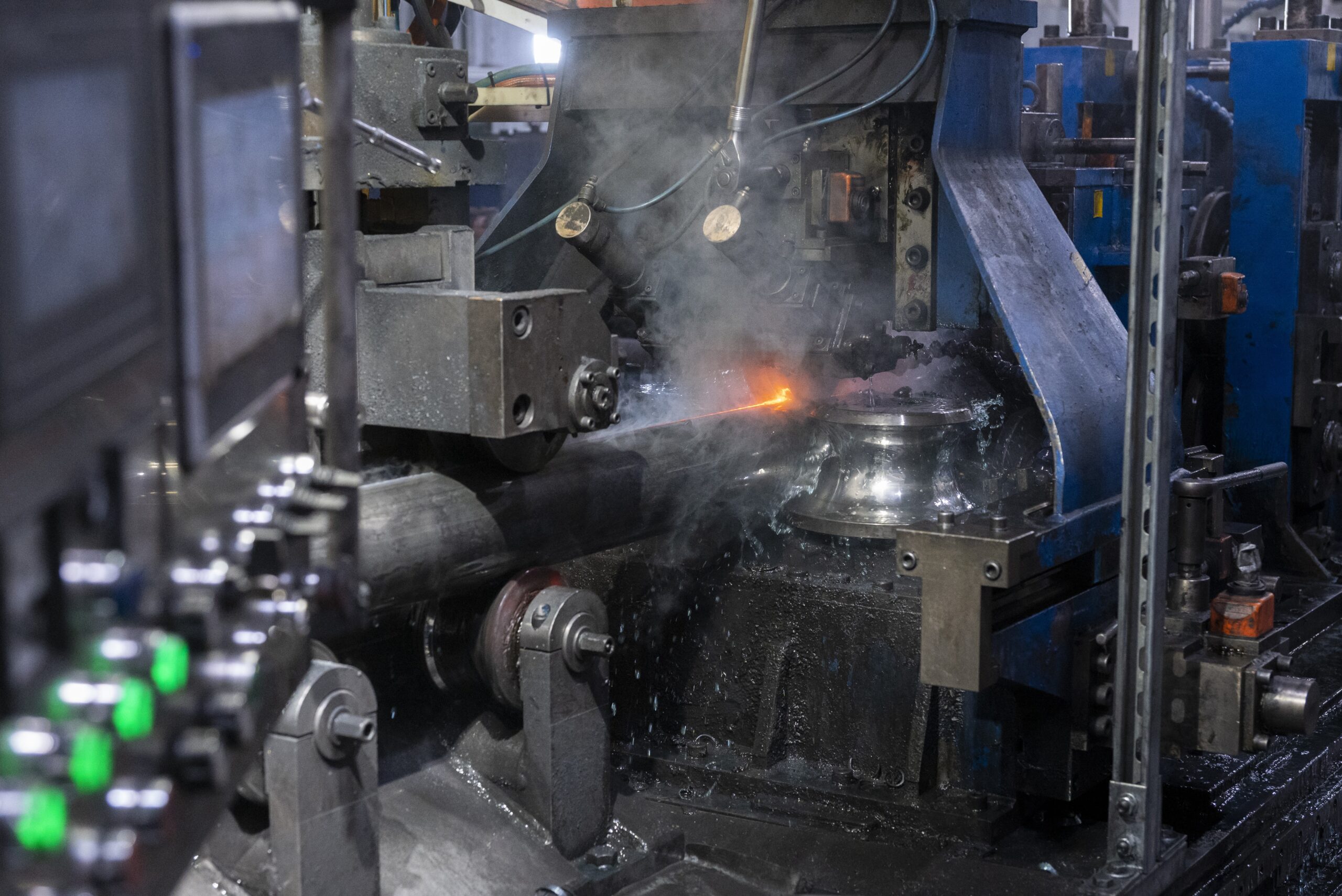 Tubing Process Machine in Action Tubing process machine welding metal with sparks and coolant in a factory.